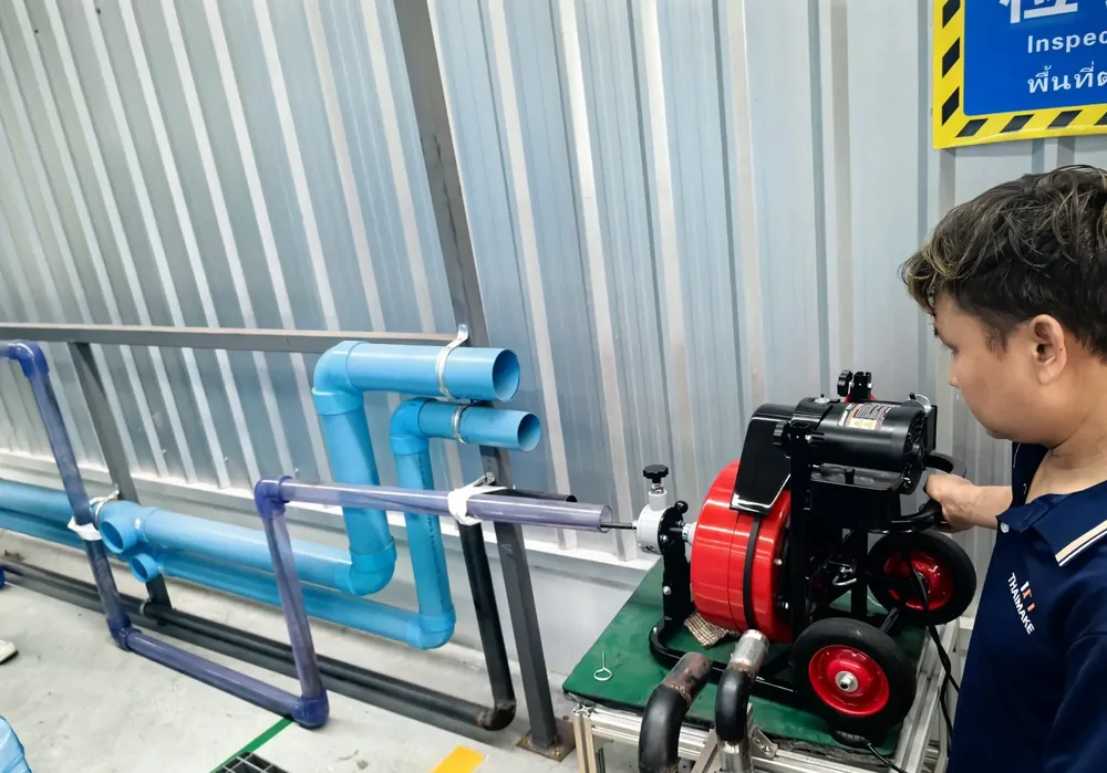 Technician using a drain cleaning machine at a municipal pipe maintenance site